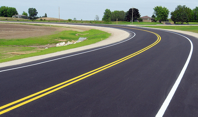 Freshly paved and painted curving rural road 