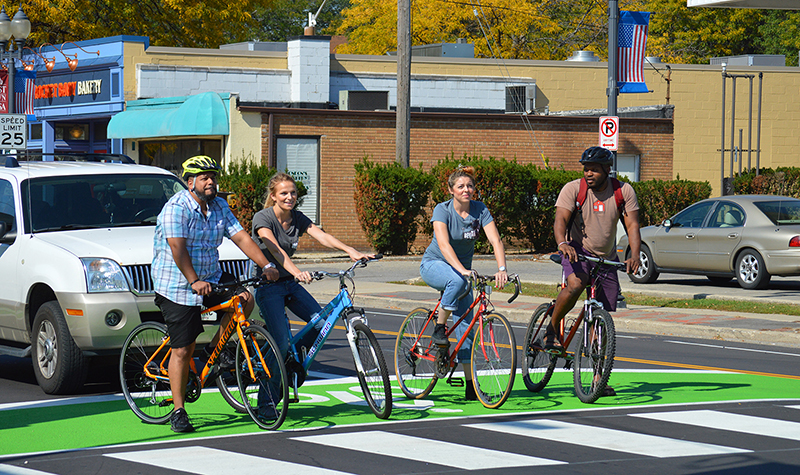 Individuals on bikes using a bike box.