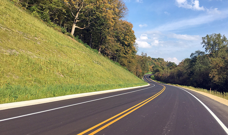 winding two-lane roadway through trees.