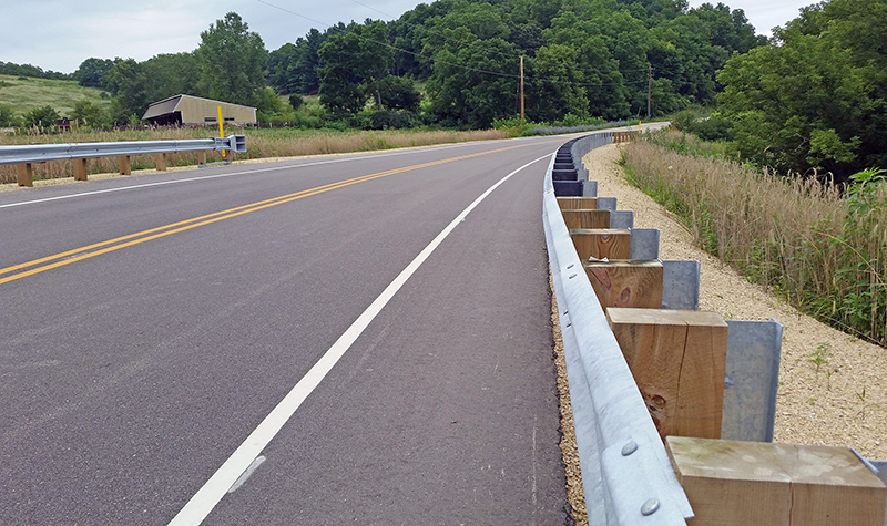 Shoulder of paved roadway with focus on guardrail