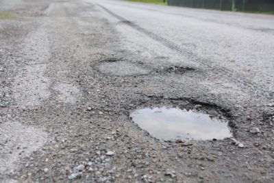 Close up of road potholes full of water