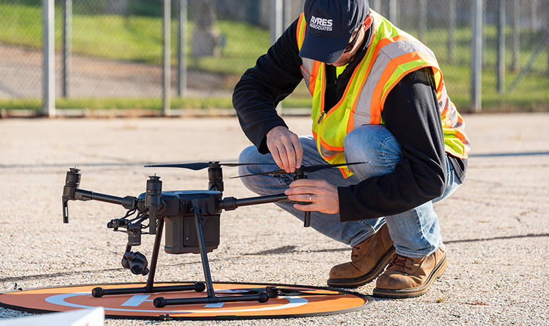 Drone on ground while technical staff inspect its components