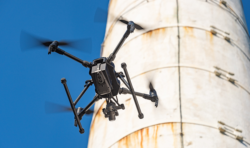 Drone hovering near smokestack