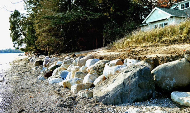 A rock wall along the the shoreline protecting from rising waves