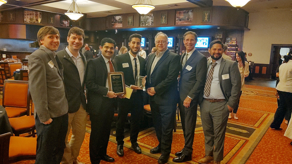 Ayres Mohamad-Waleed Gebarin featured with his award in a group of people.