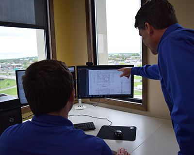 Two staff members discussing by computer screen