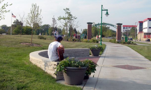 Park with person sitting on concrete bench.