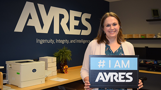 Ayres Employee-owner holding I Am Ayres sign.